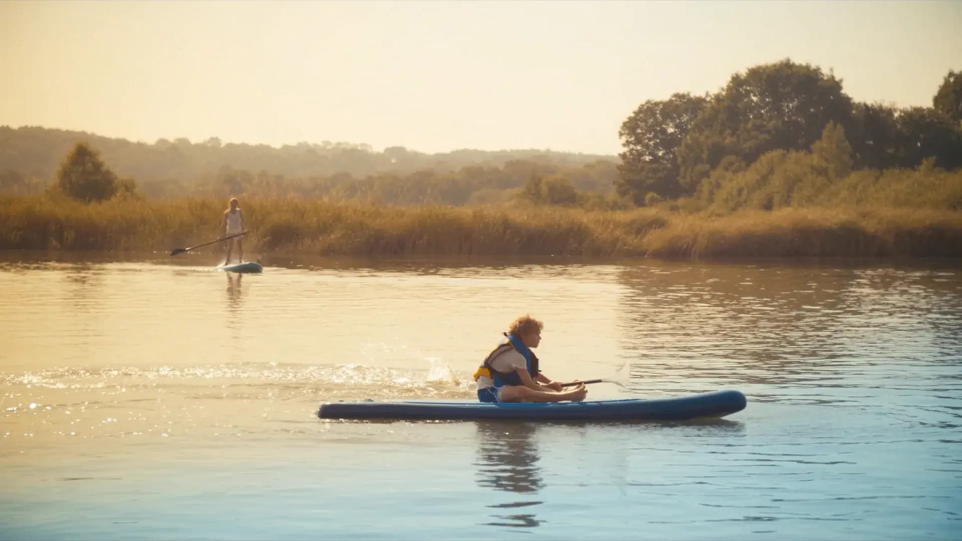 SUP met kinderen: vanaf welke leeftijd en welk board past?: Kind op een kleine SUP-board met zwemvest
