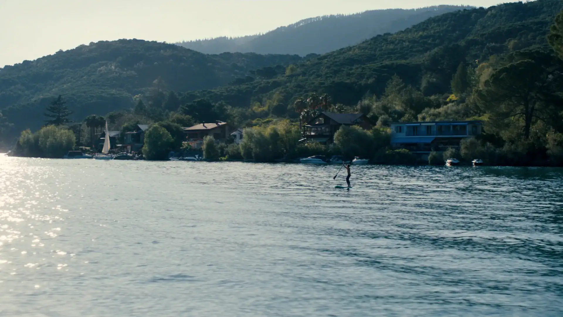 SUP vakantie: complete gids voor bestemmingen, vervoer en planning — SUP-paddler op een mediterraans Europees meer in vakantiesfeer